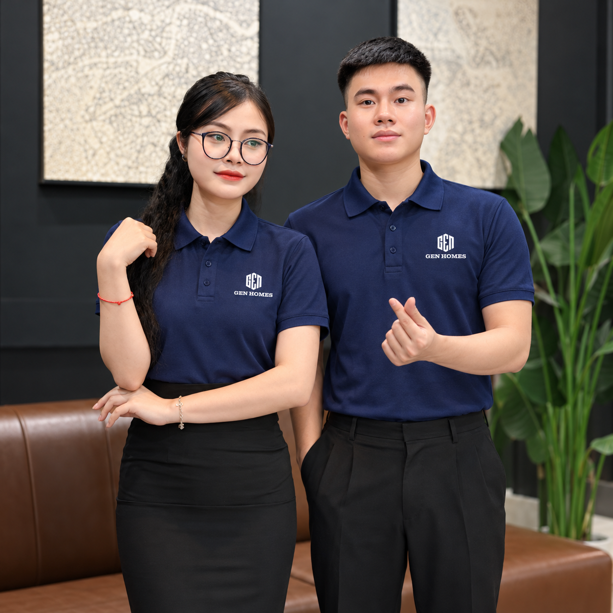Nam và nữ mặc áo polo đồng phục GEN HOMES xanh navy, phối quần tây và chân váy đen