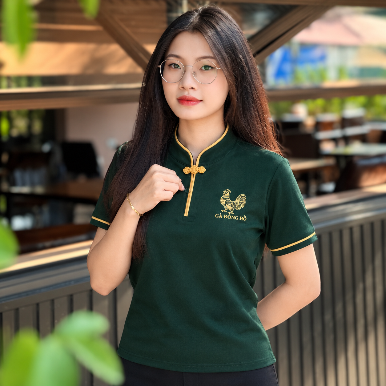 Chi tiết logo cổ tàu viền vàng và nút thắt trang trí trên áo đồng phục nhà hàng