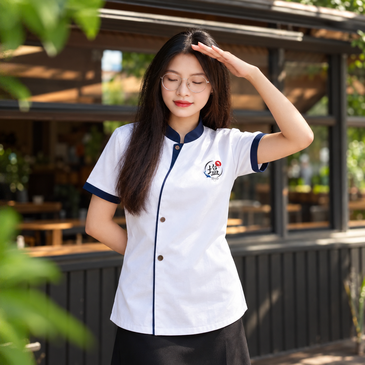 Nhân viên nữ mặc áo đồng phục trắng cổ trụ viền xanh navy, vạt dài phối chân váy đen