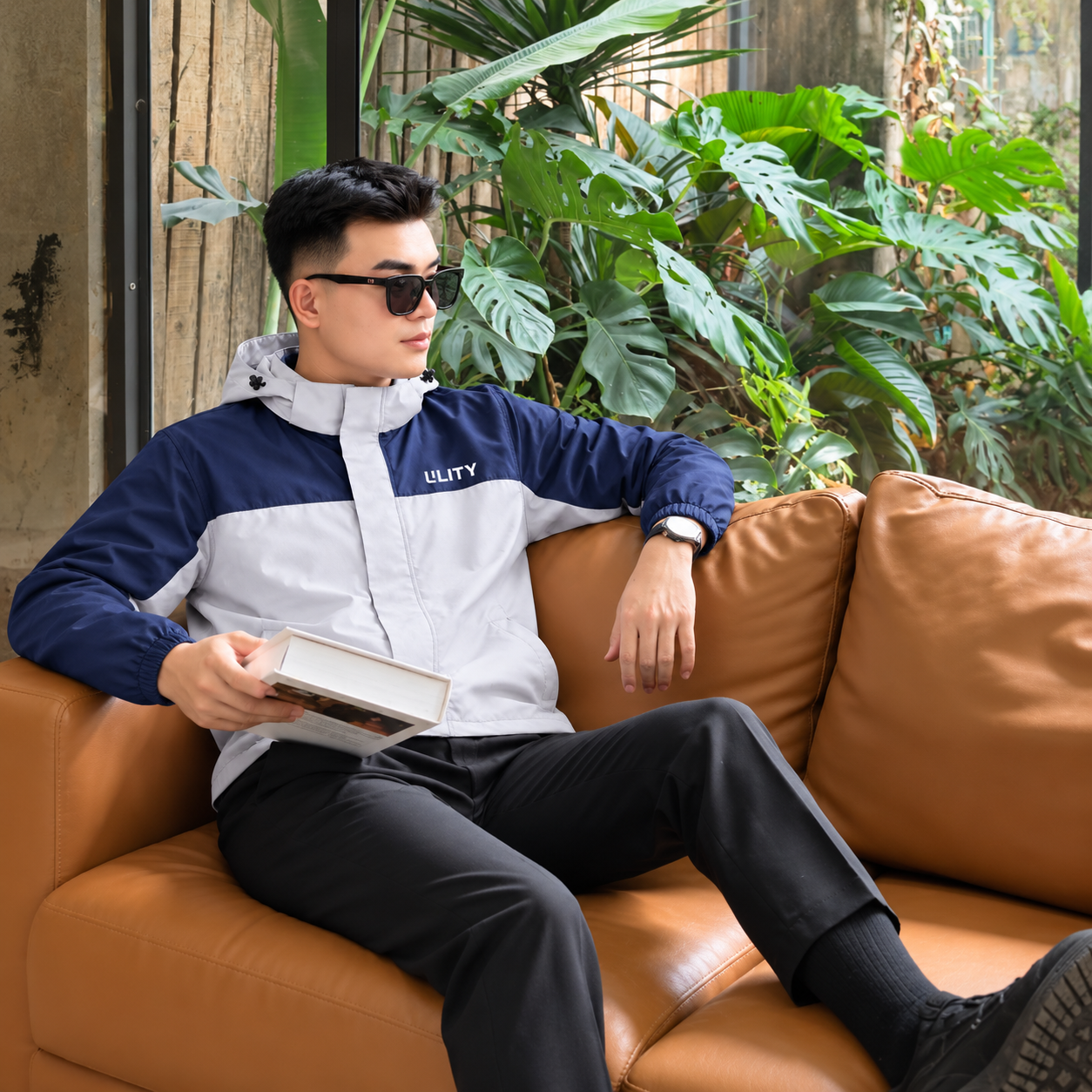 Người mẫu mặc áo khoáng phối cùng quần âu ngồi trên sofa