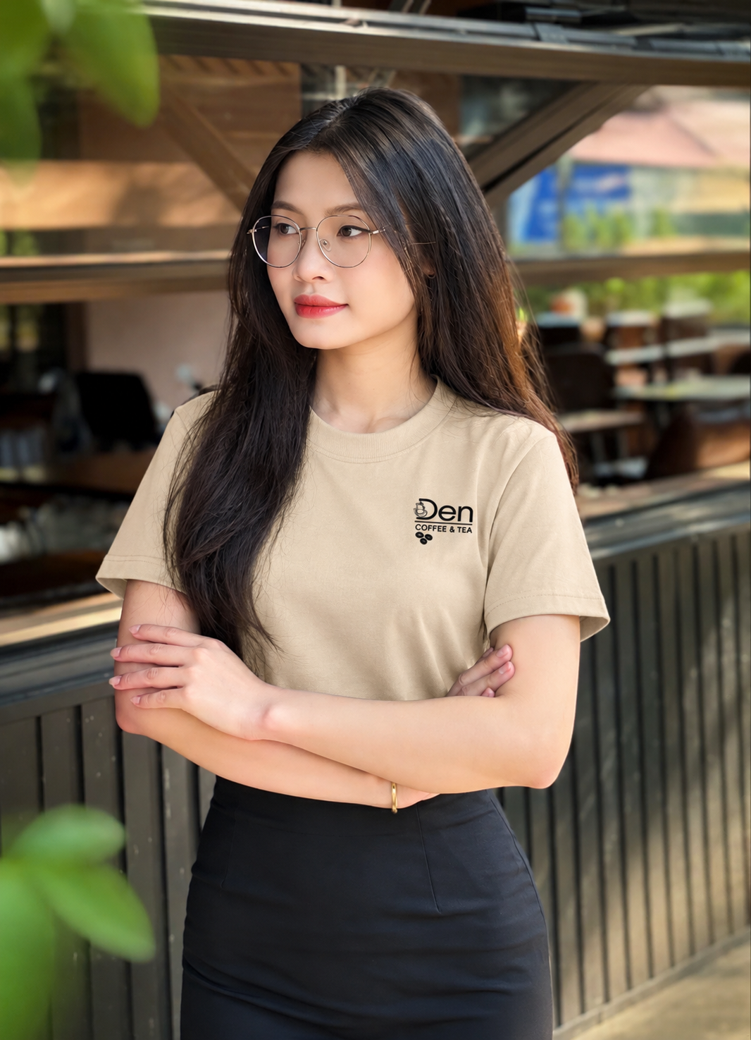 Nữ nhân viên mặc áo thun đồng phục quán cafe màu be phối chân váy đen