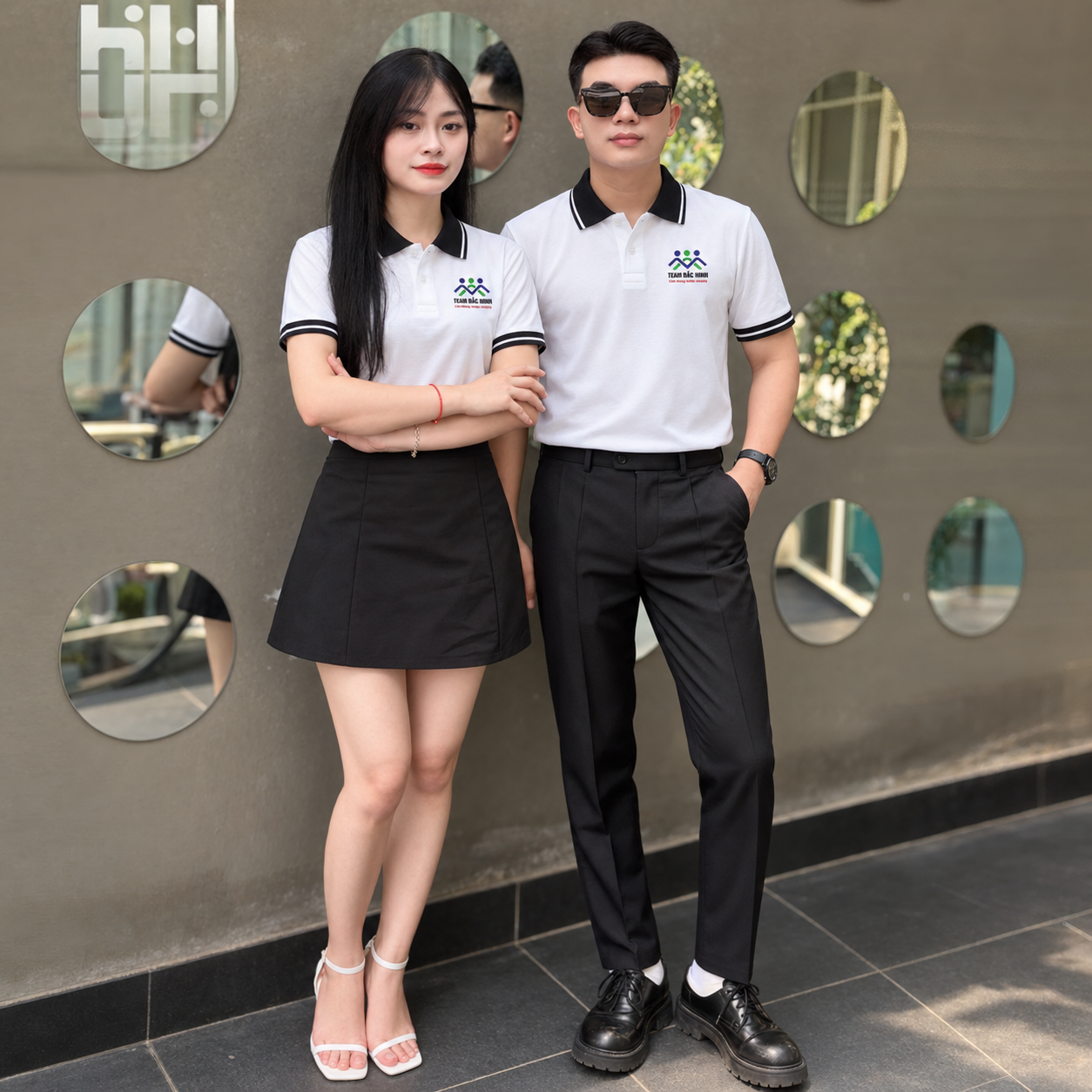 Hai người mẫu nữ mặc áo polo đỏ đô phối kem Team Bắc Ninh